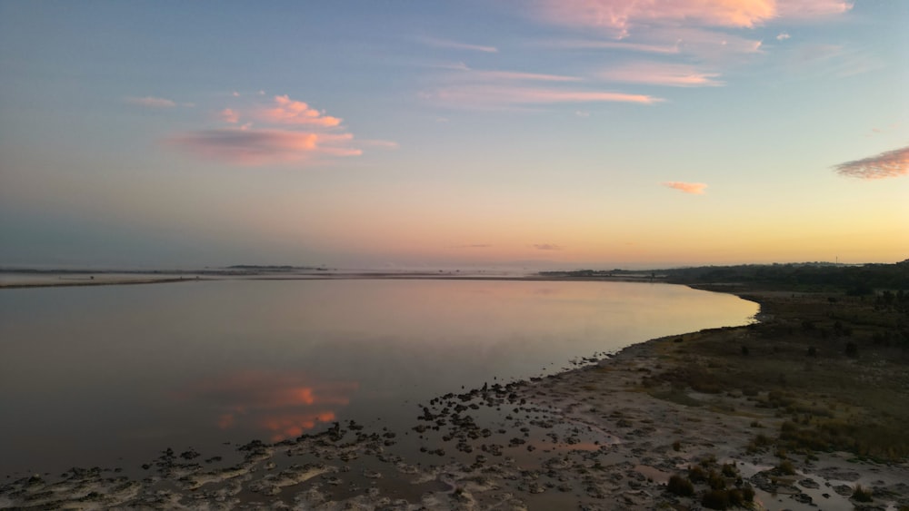 a large body of water with a sky in the background