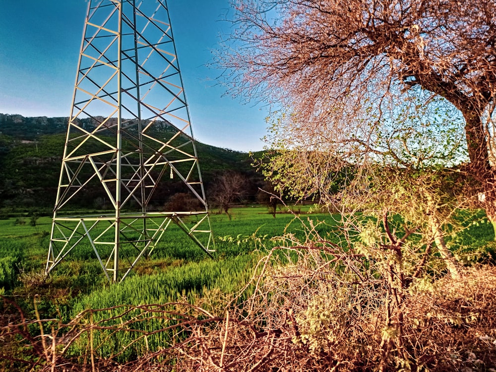 a tall metal tower sitting on top of a lush green field