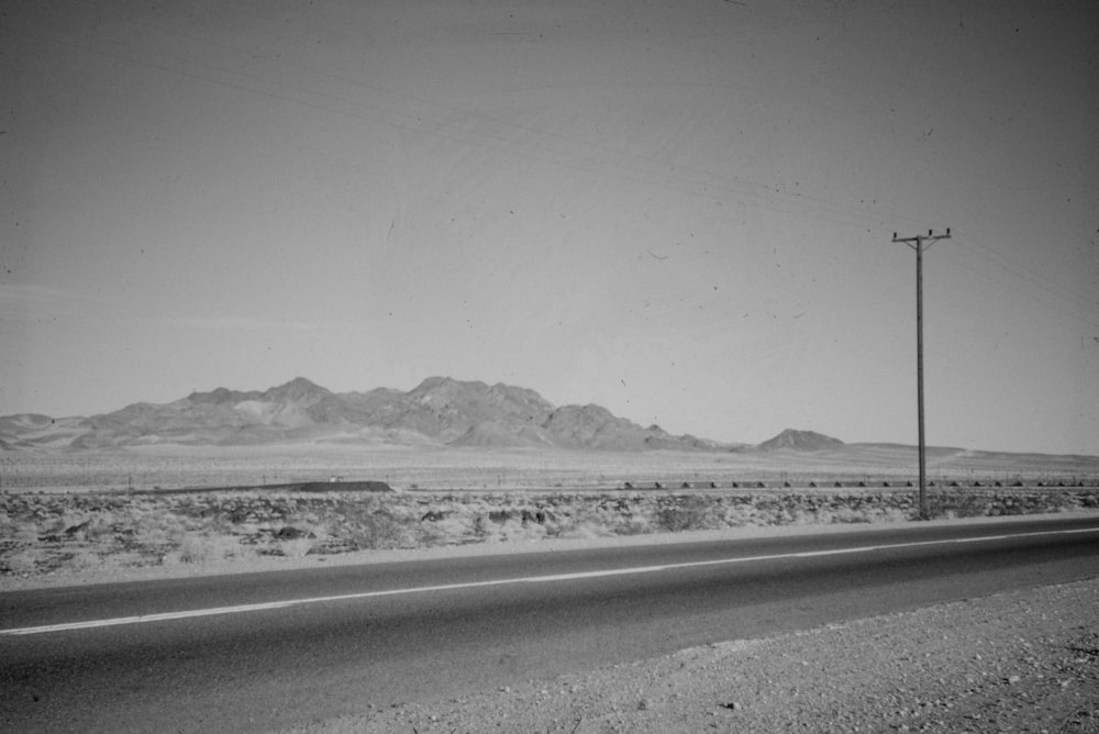 a black and white photo of a road in the desert