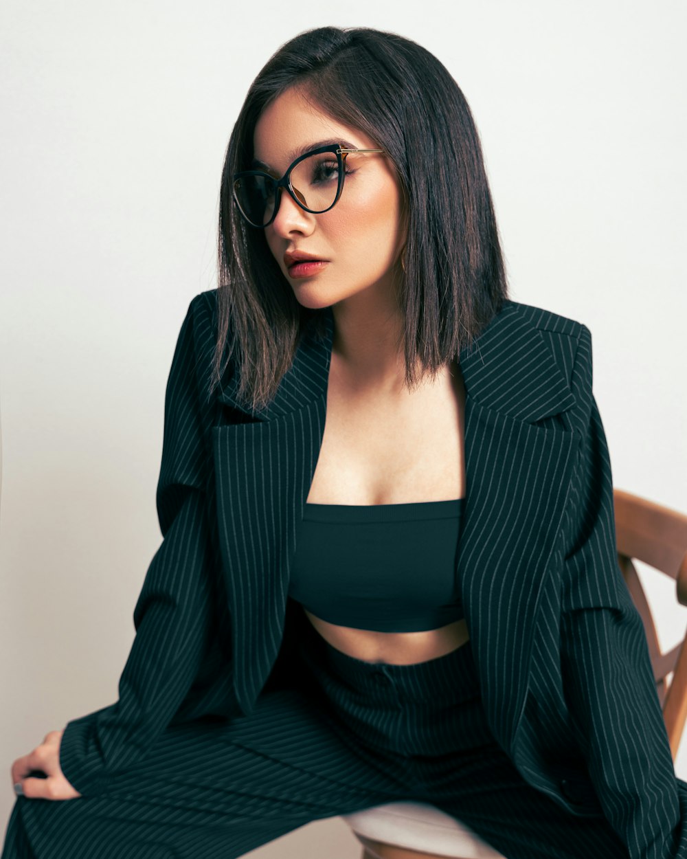 a woman sitting on a chair wearing glasses