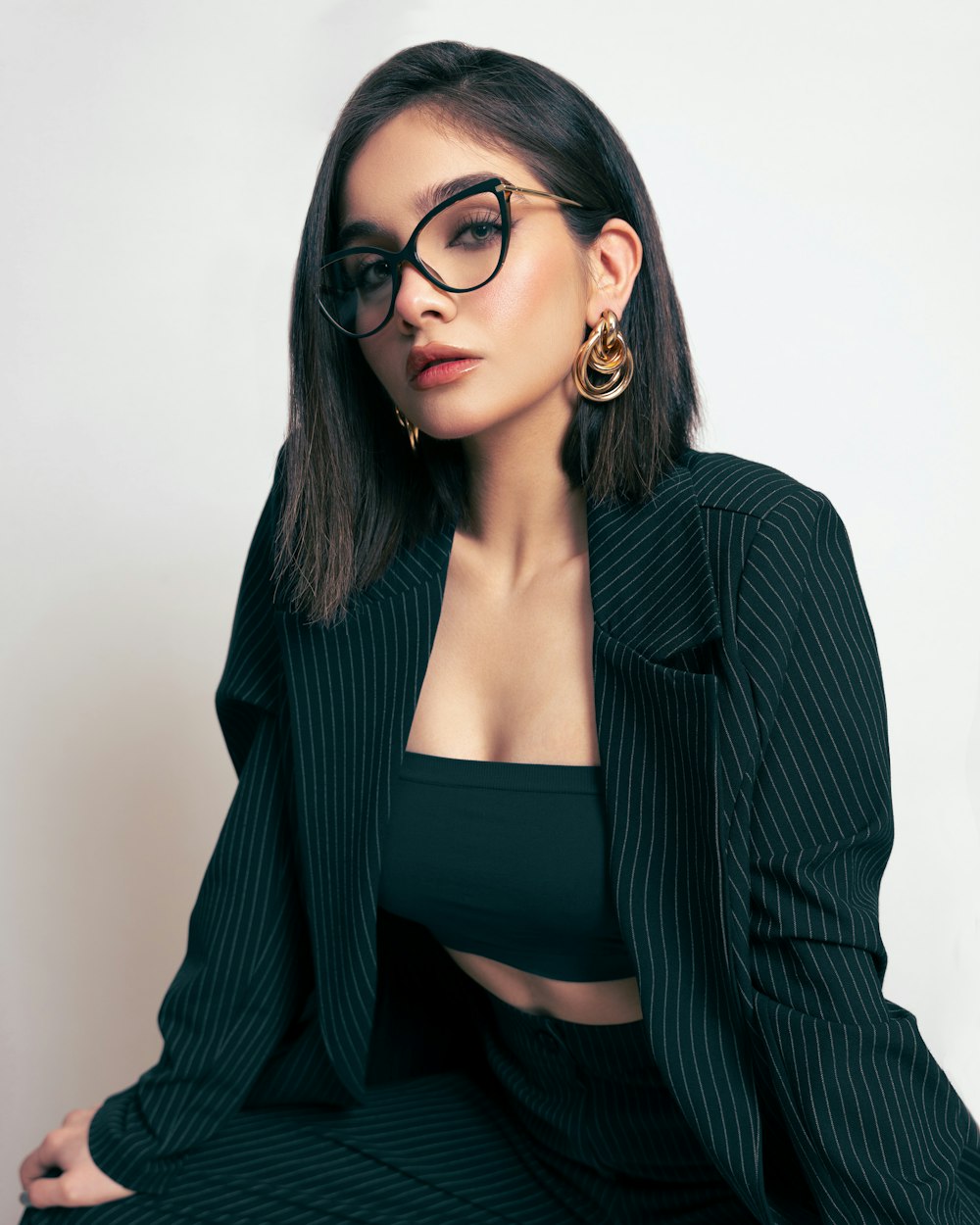 a woman in a suit and glasses posing for a picture