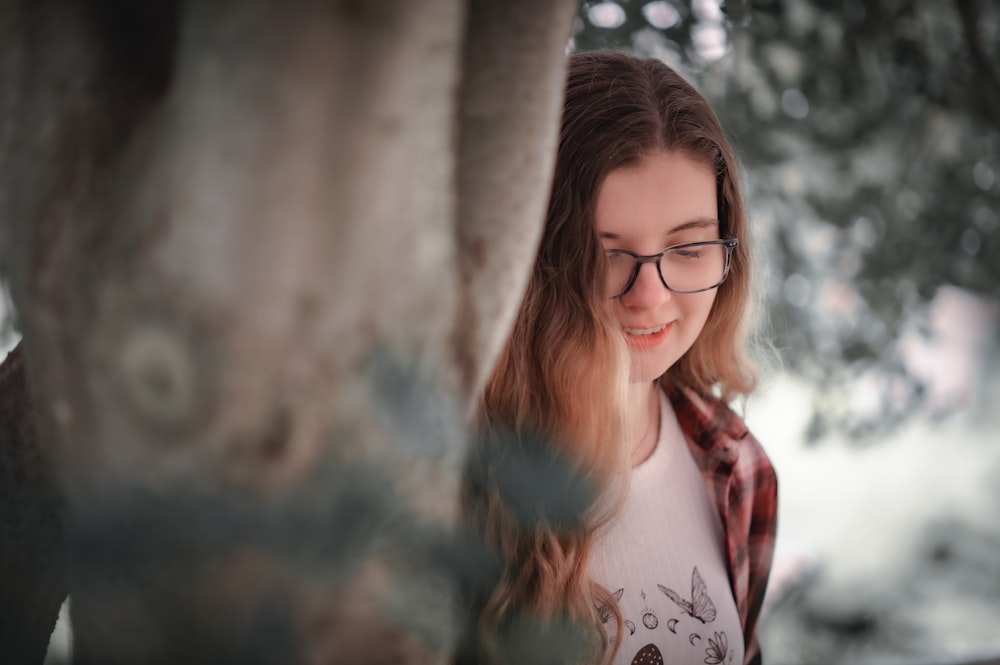 a girl wearing glasses looking at her cell phone