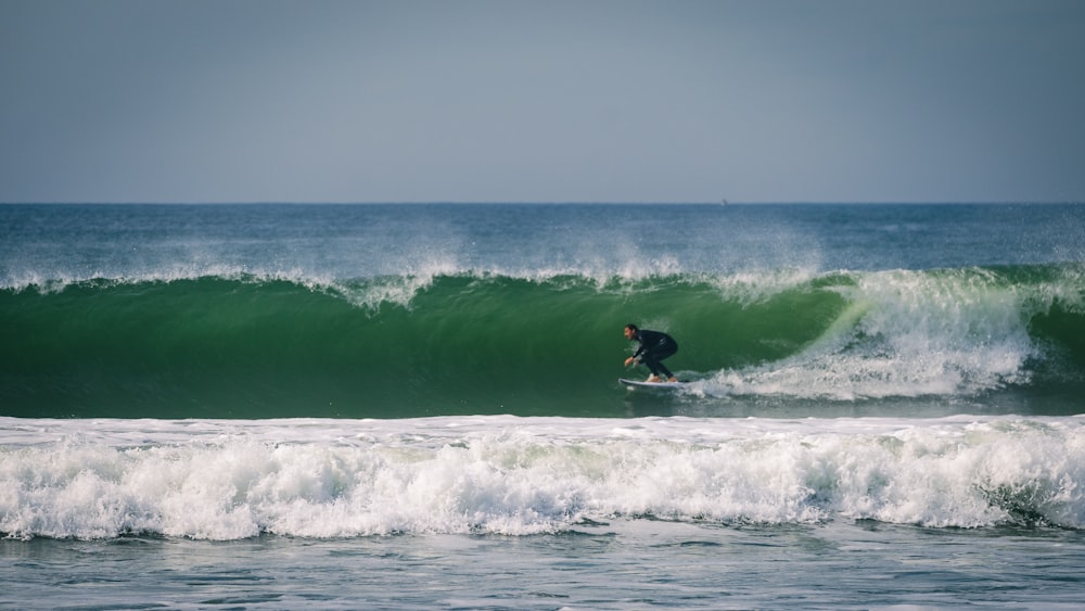 a man riding a wave on top of a surfboard