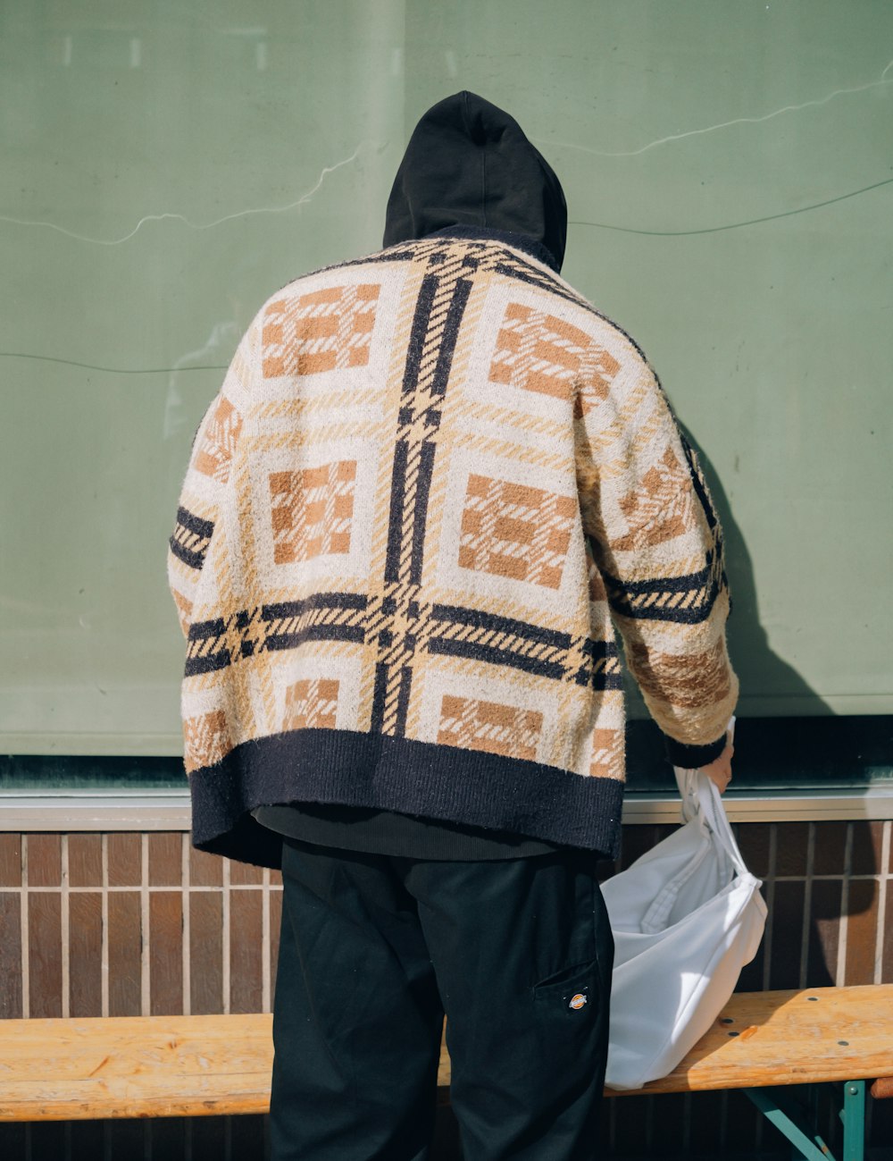 a person standing on a bench holding a bag