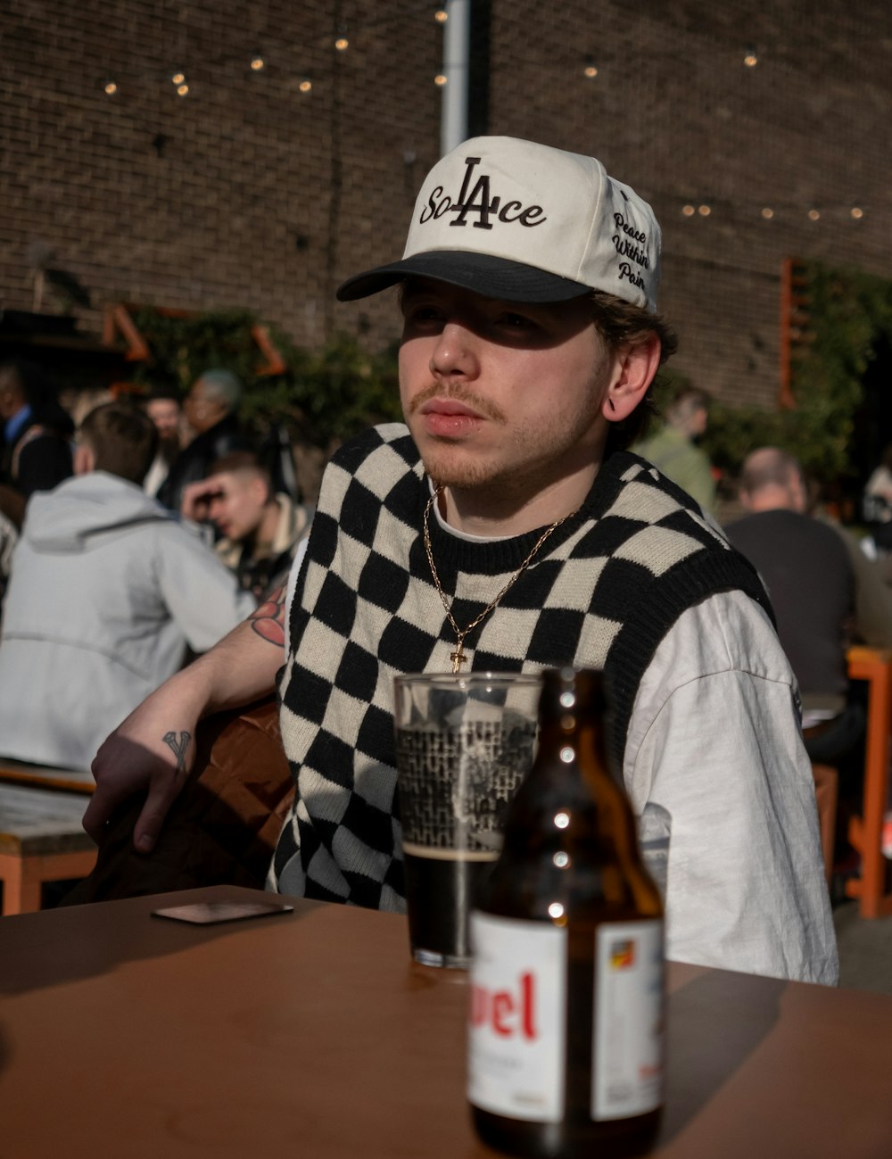 a man sitting at a table with a bottle of beer