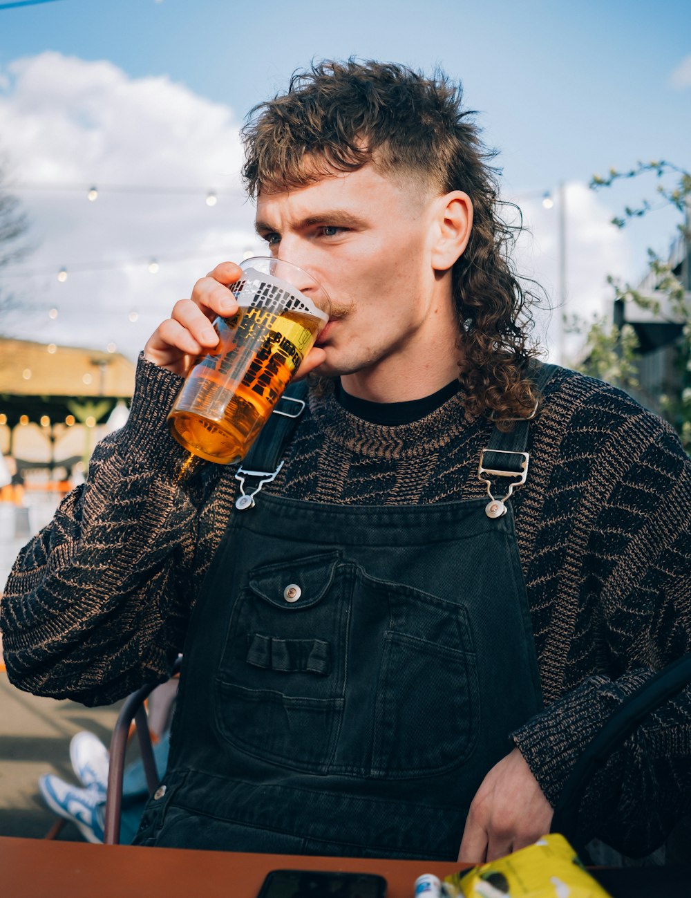 un hombre de pelo largo bebiendo una cerveza