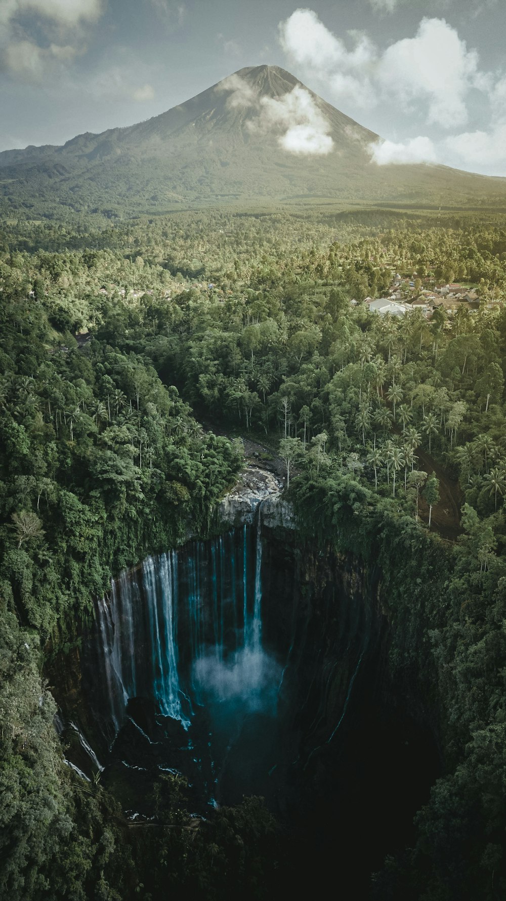 a large waterfall in the middle of a forest