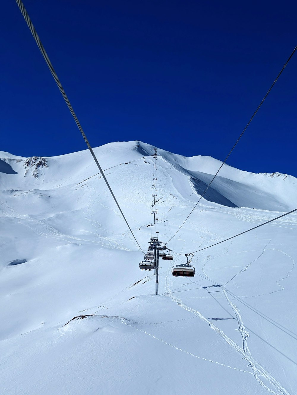 a ski lift going up a snowy mountain