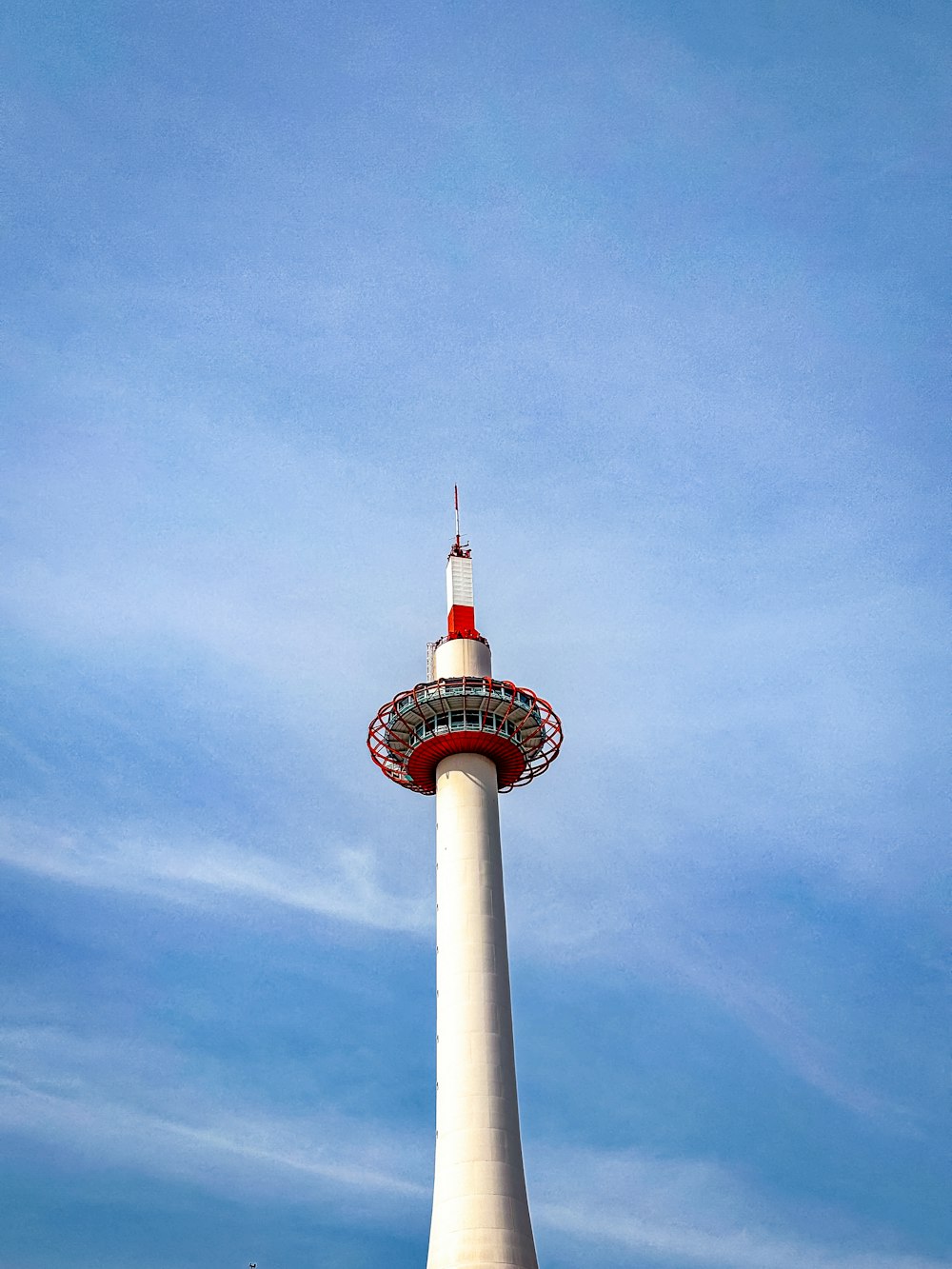 ein hoher weißer Turm mit roter Spitze