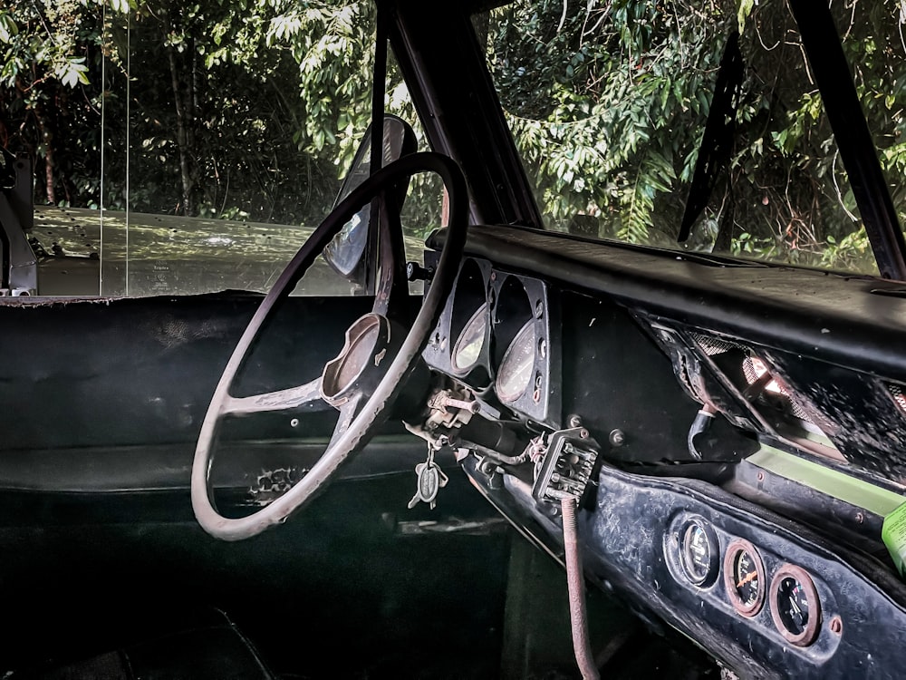 the interior of an old car with trees in the background