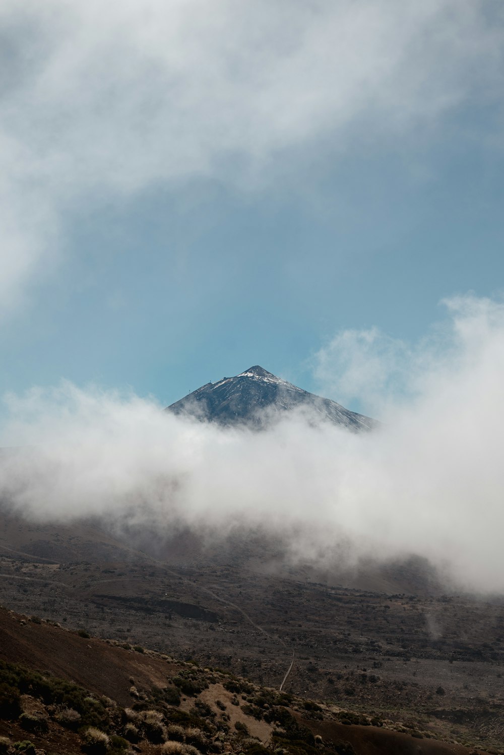 uma montanha coberta de nuvens em um dia ensolarado