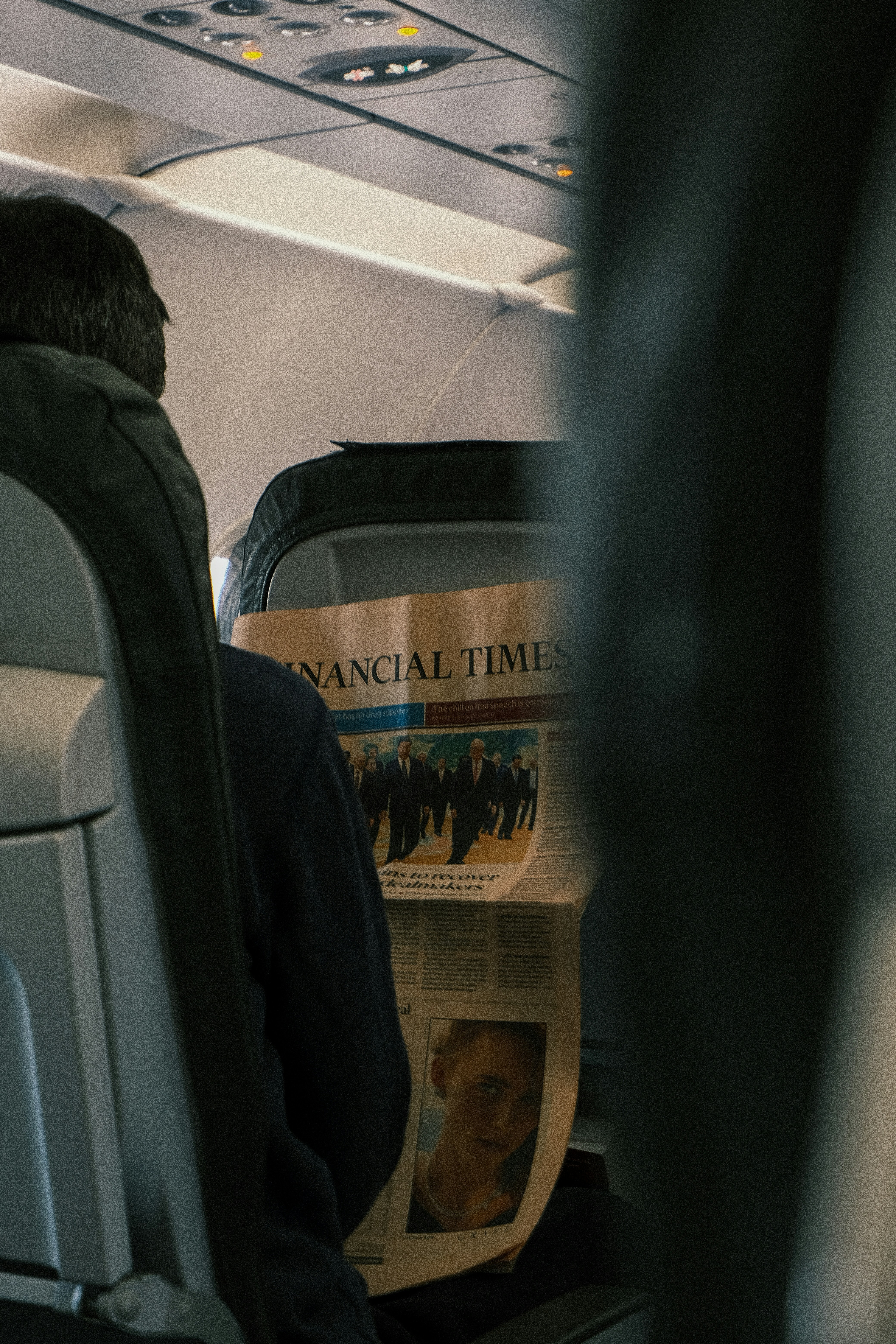 a man reading a newspaper on an airplane