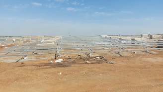 a group of metal structures in the middle of a dirt field