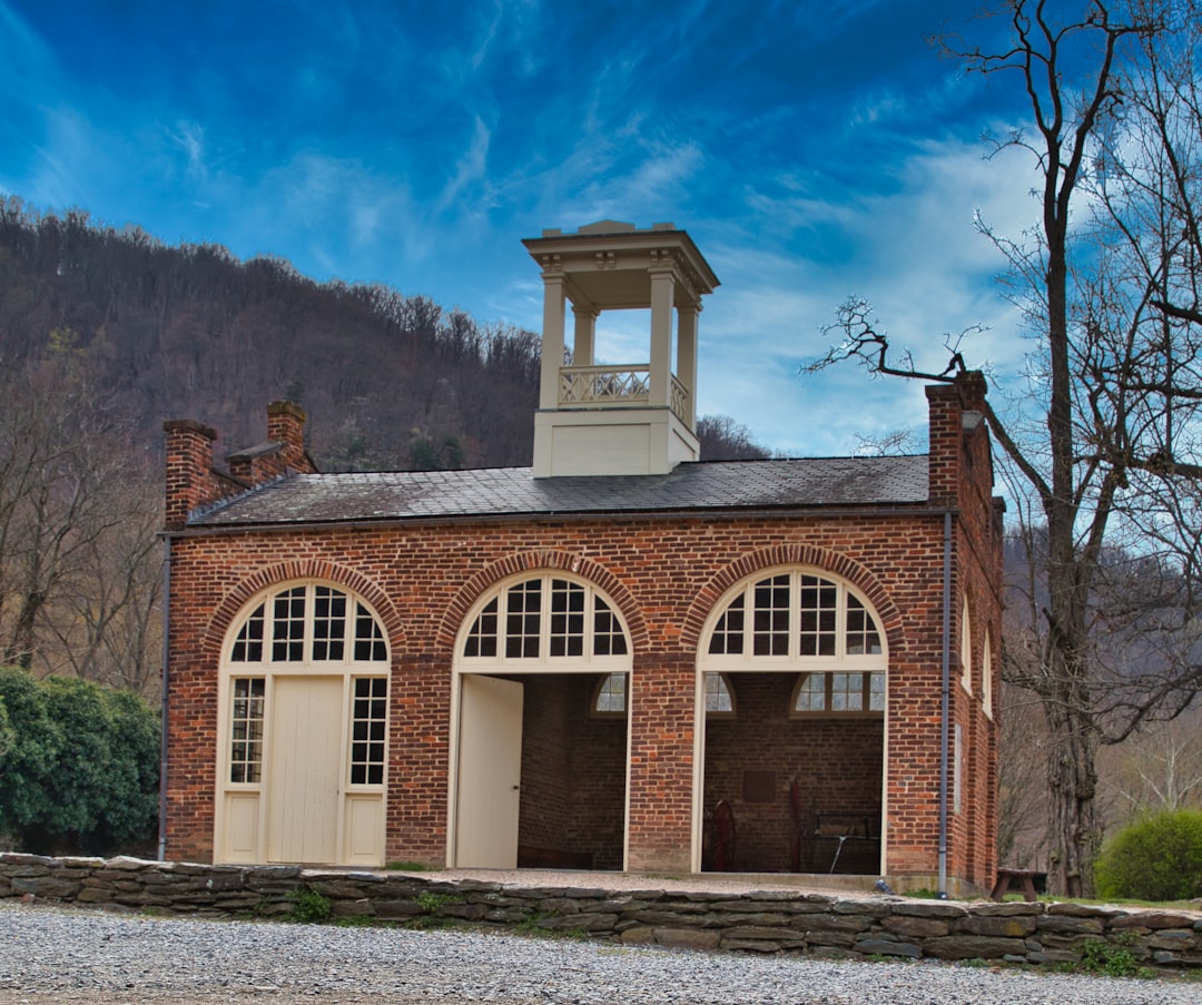 a brick building with a clock tower on top of it, John Brown Fort in Harper