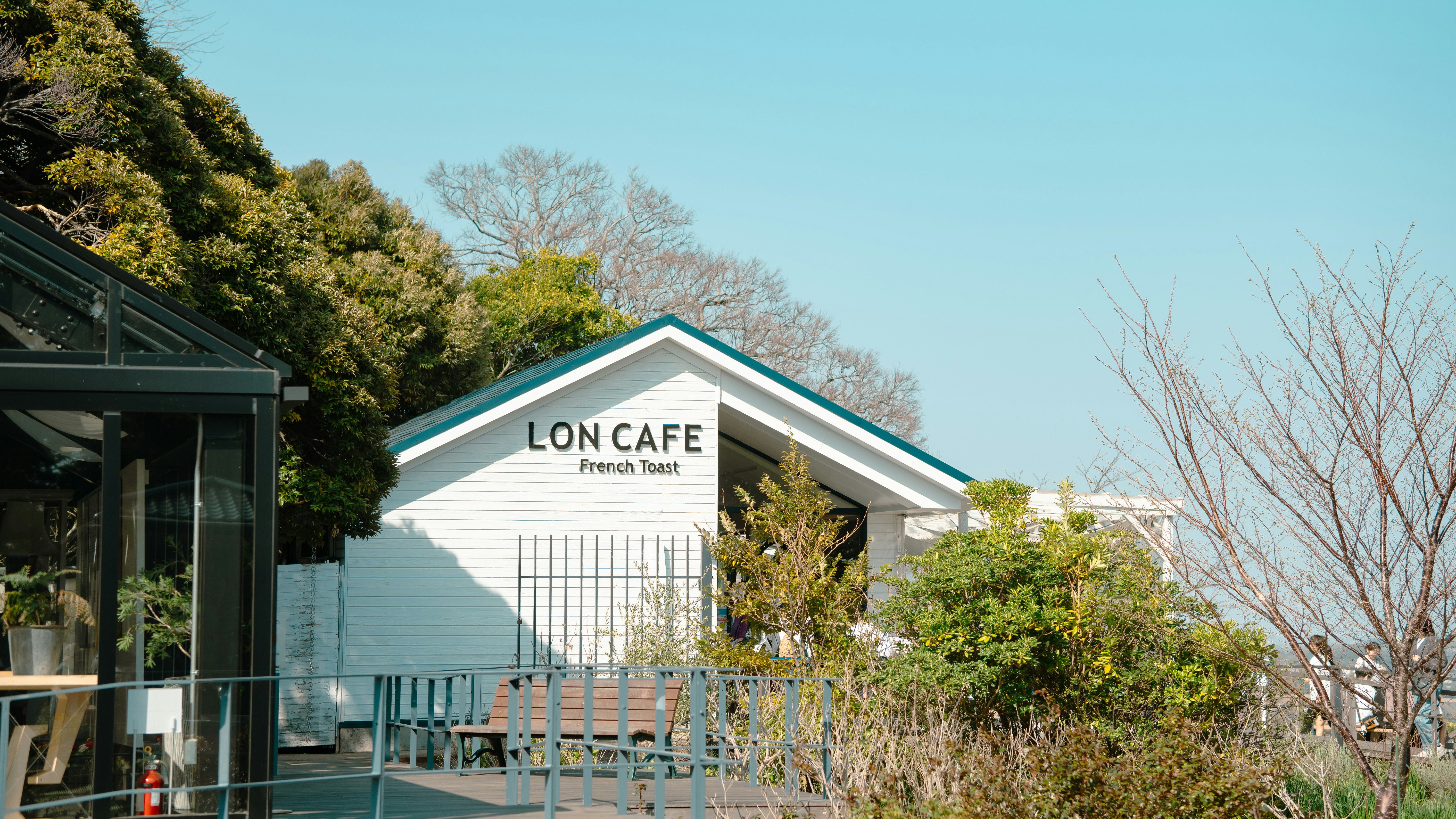 A white building with a sign that says long cafe