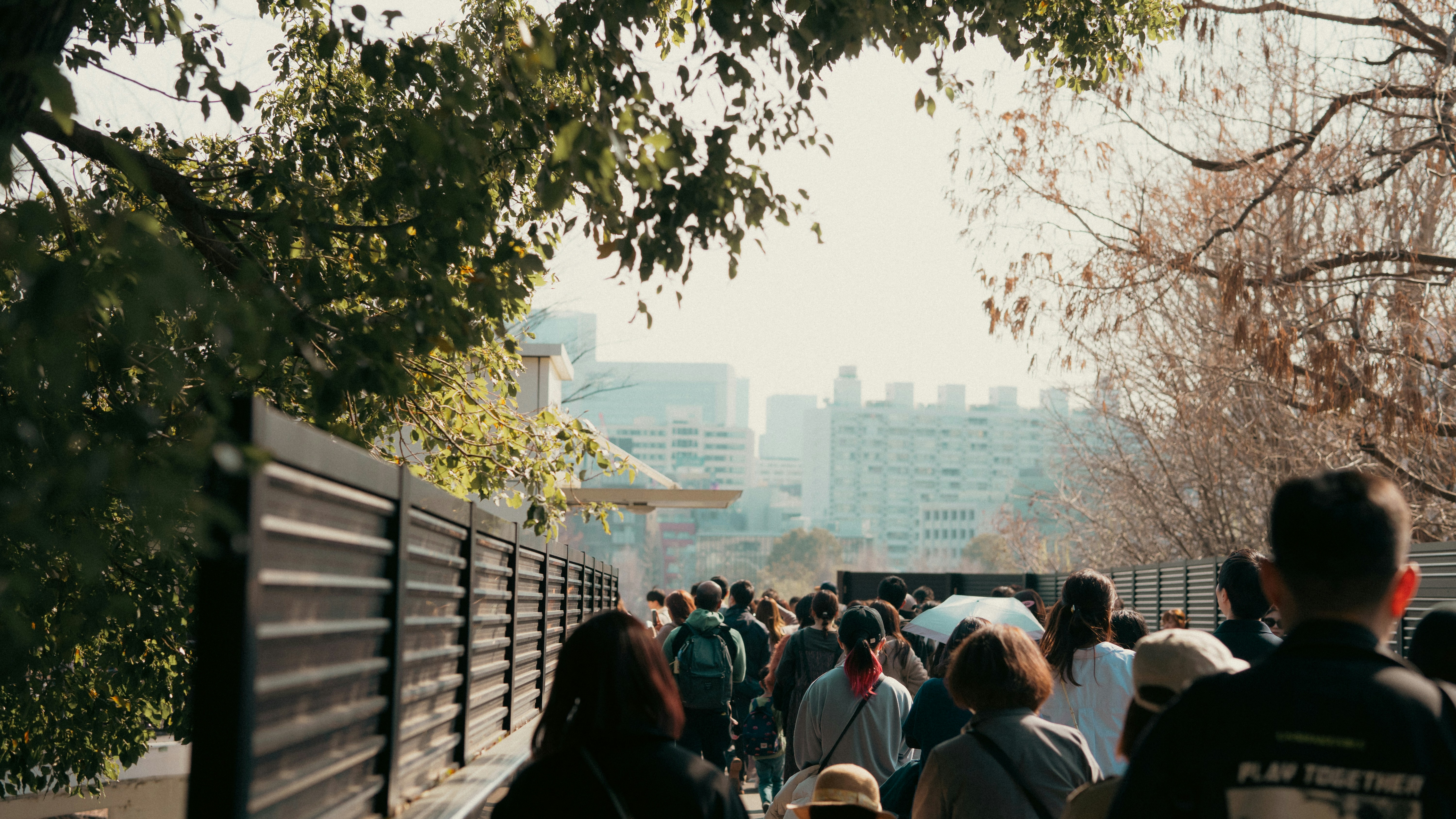 a large group of people walking down a sidewalk
