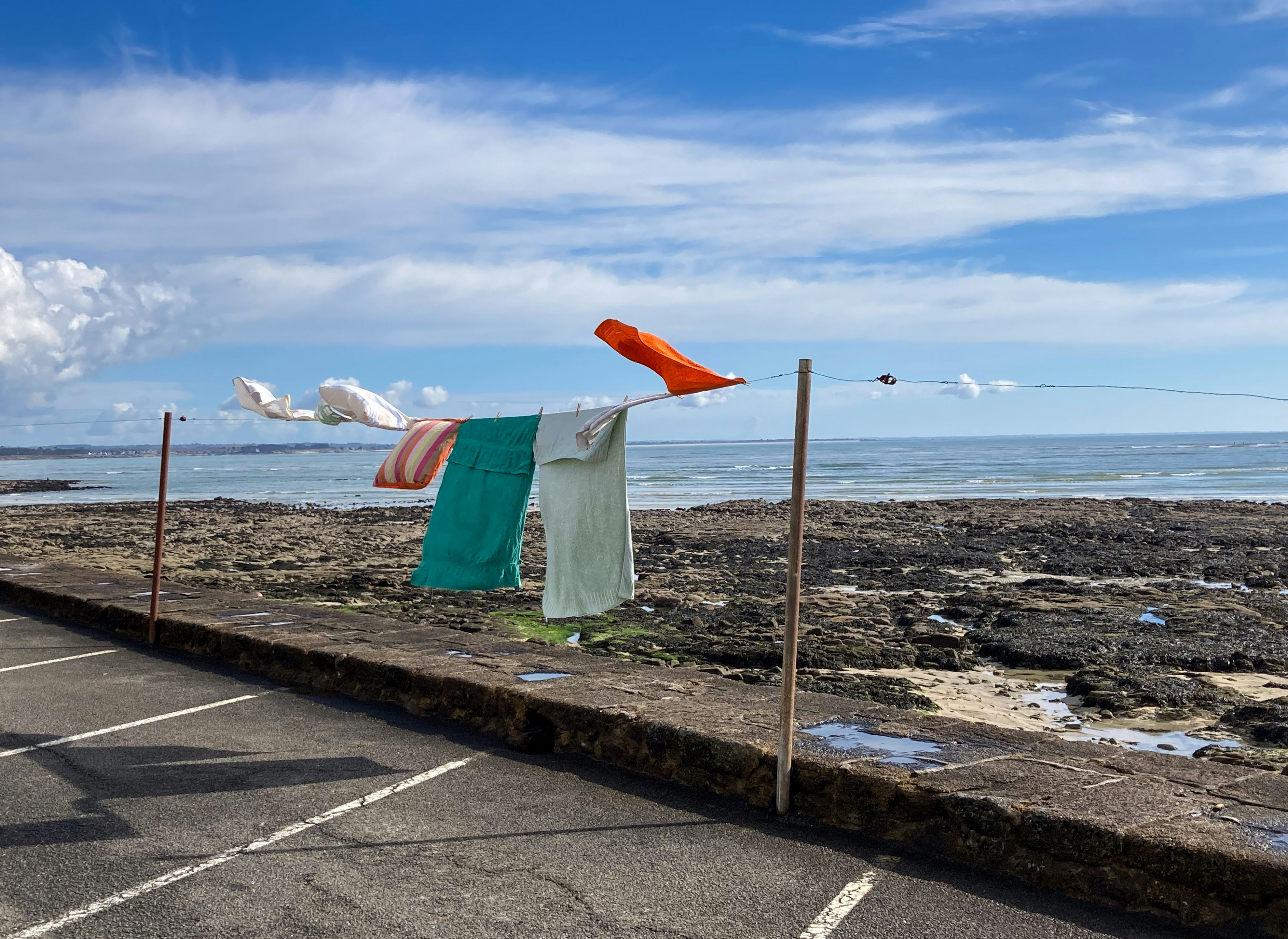 a row of clothes hanging on a clothes line next to the ocean