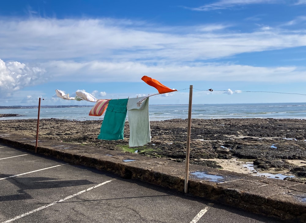 a row of clothes hanging on a clothes line next to the ocean
