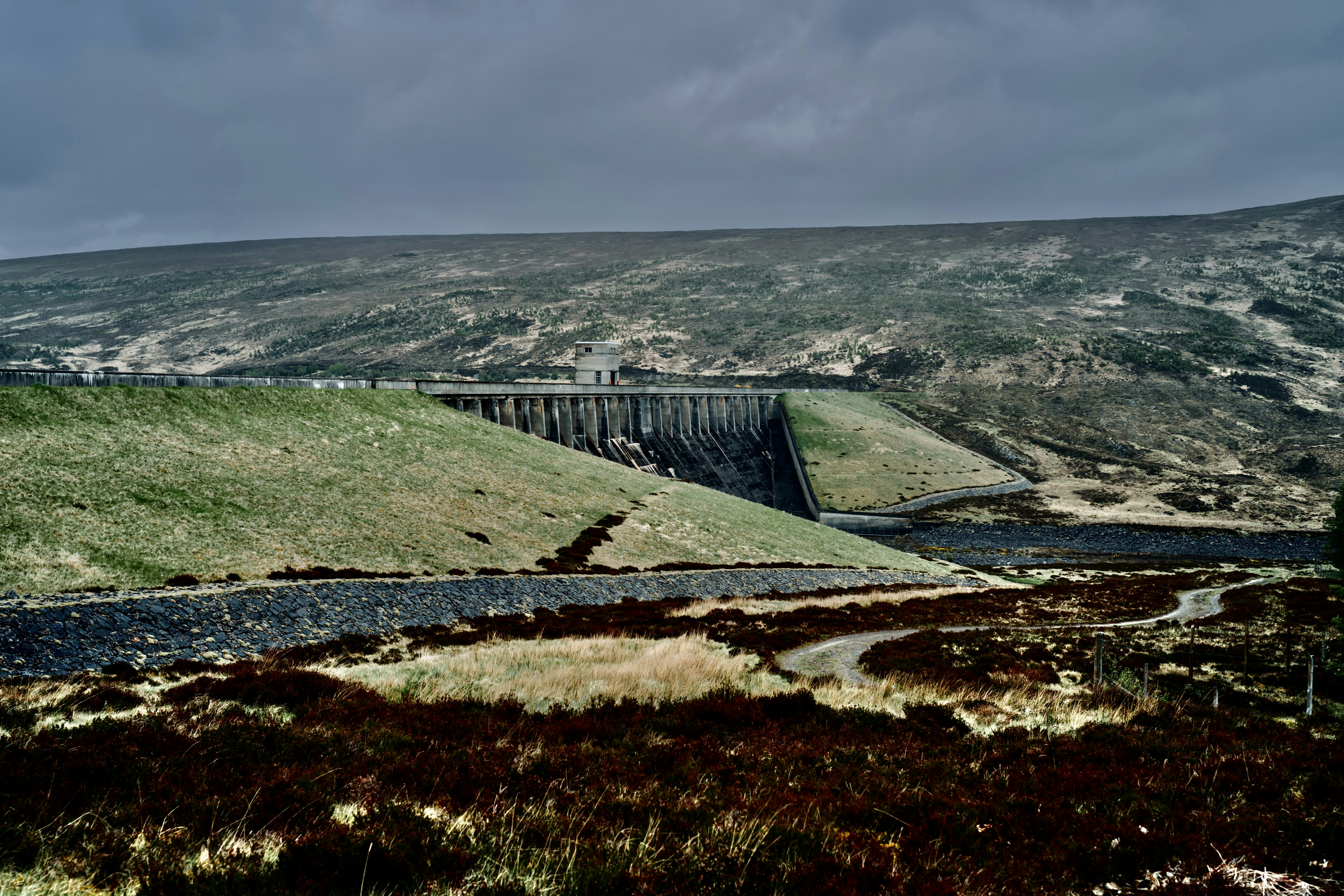a scenic view of a dam in the mountains, 