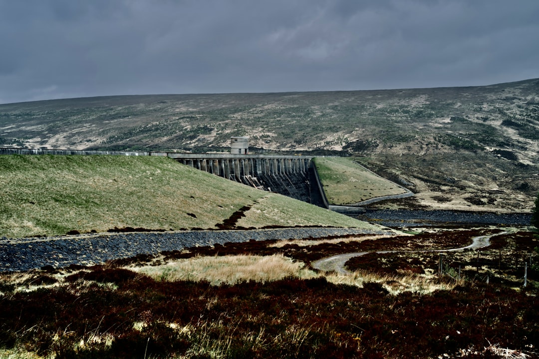 a scenic view of a dam in the mountains,