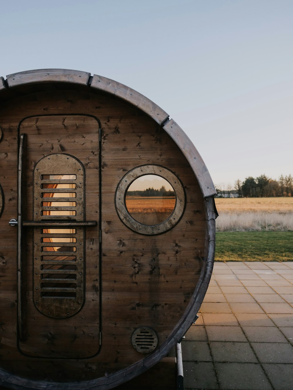 a wooden barrel sitting on top of a sidewalk