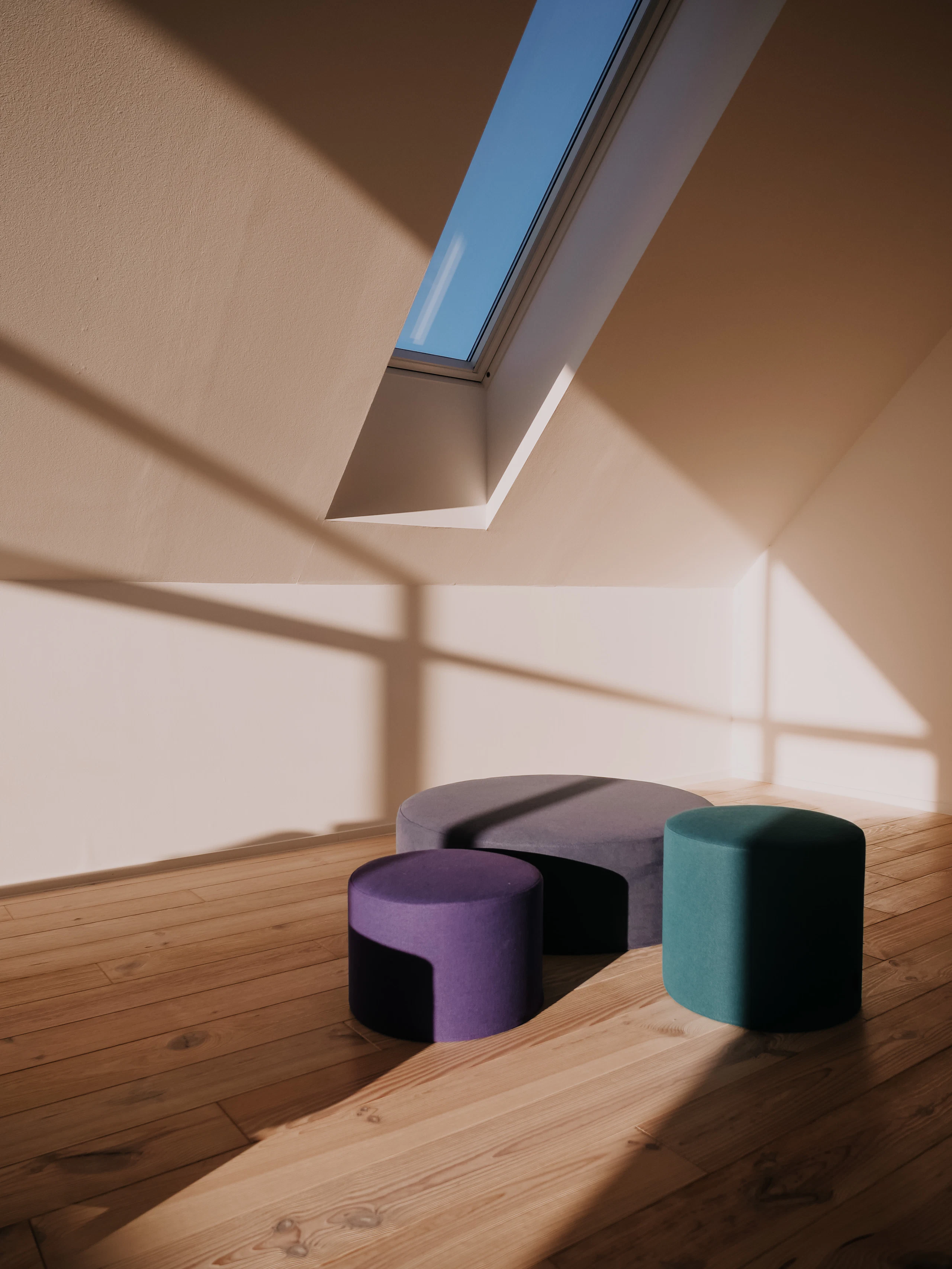 A calm room crossed by geometric bands of light and shadow