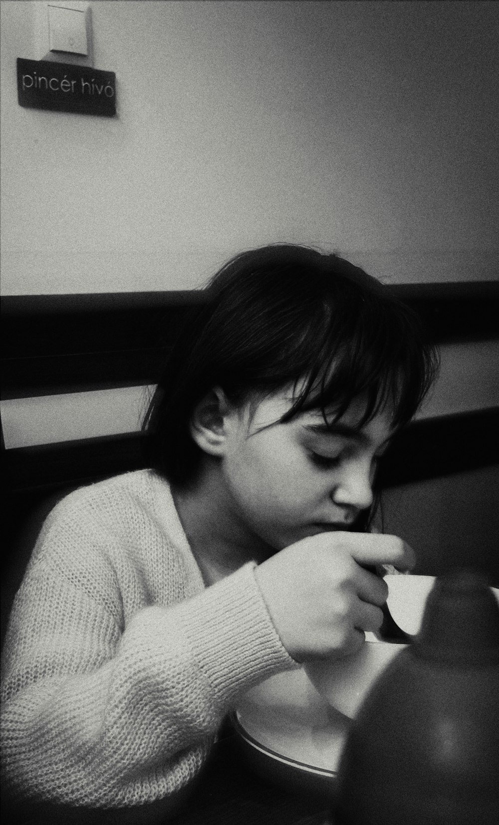 uma menina sentada em uma mesa comendo comida