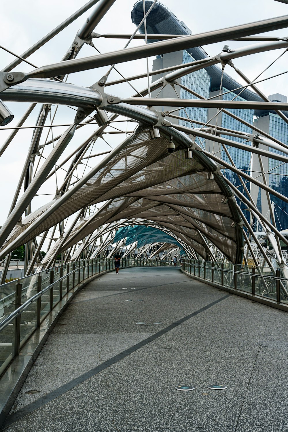 a walkway with a metal structure and a building in the background
