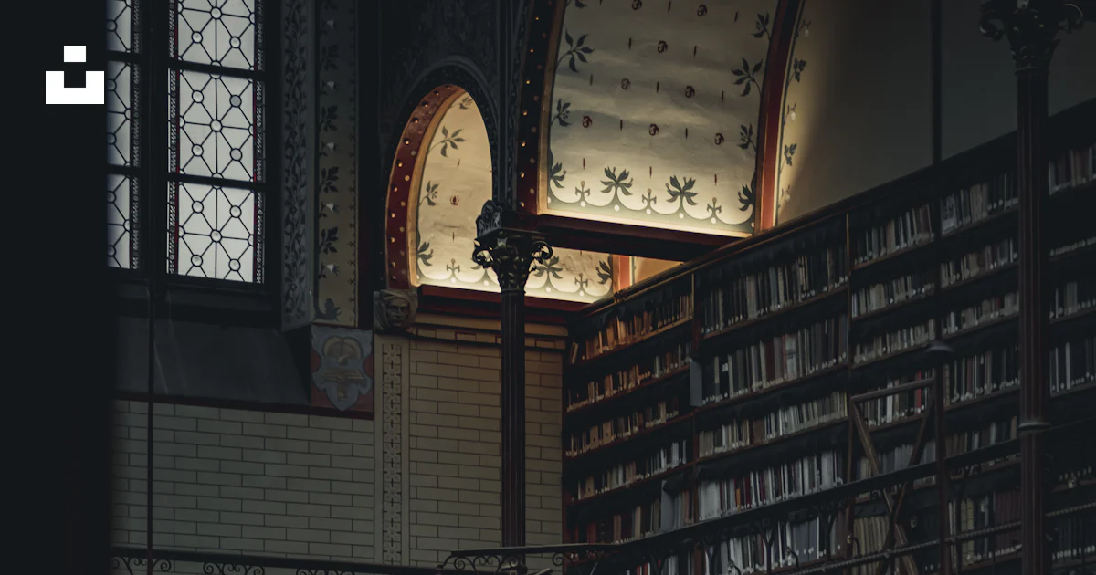 A large library with a spiral staircase and lots of books photo – Free ...