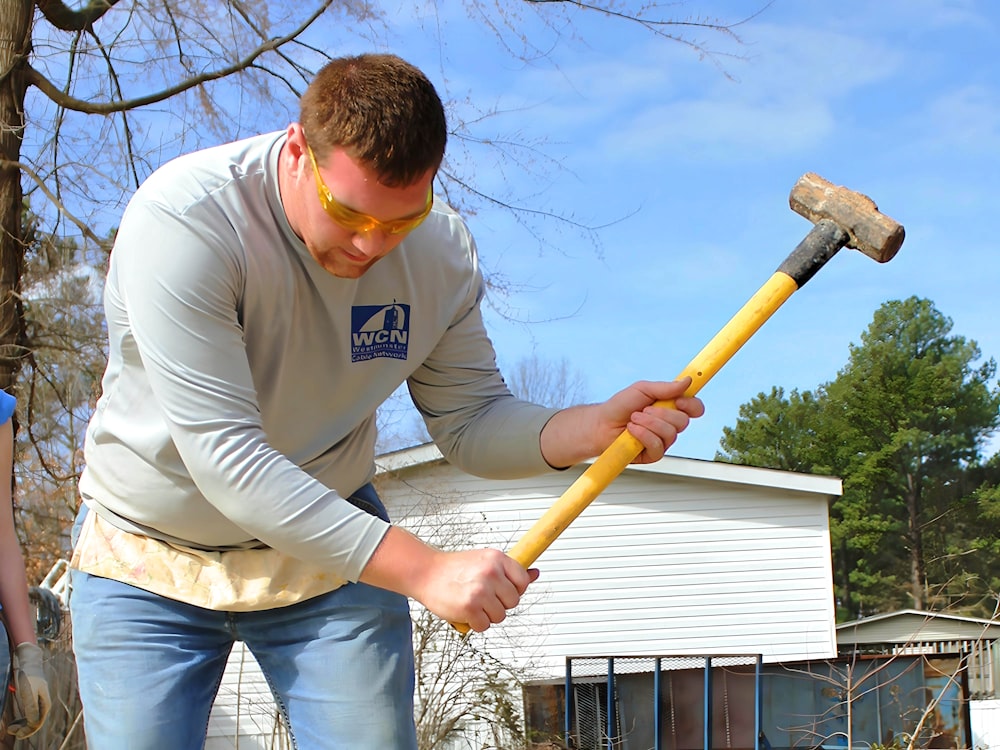 a man holding a hammer and a large hammer