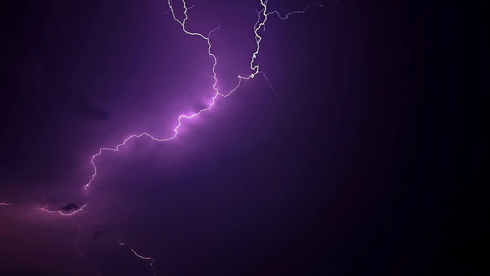 a purple and black photo of a lightning bolt