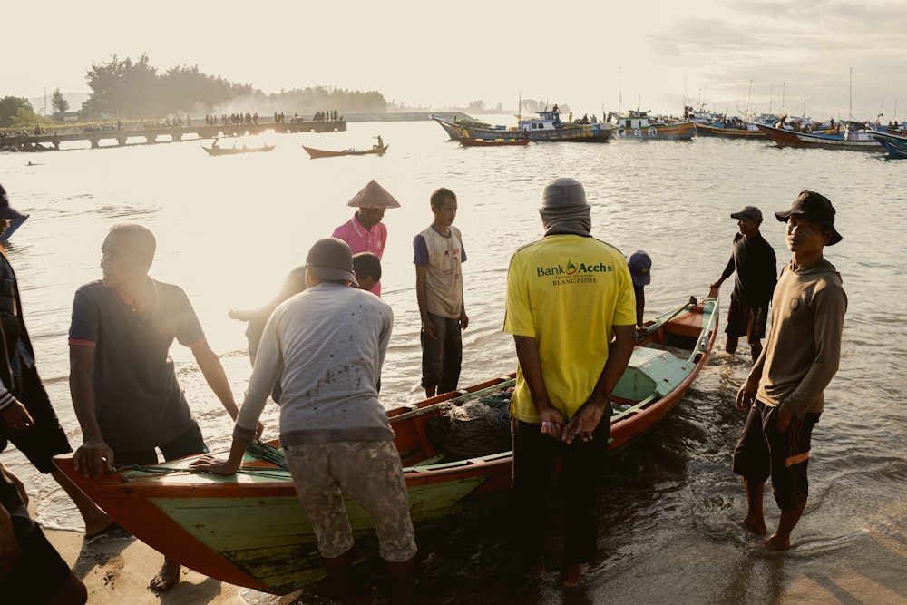 a group of people standing around a boat in the water