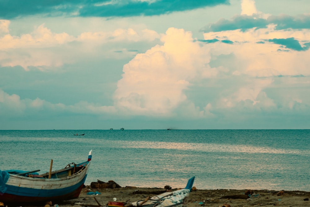 a boat sitting on top of a beach next to the ocean