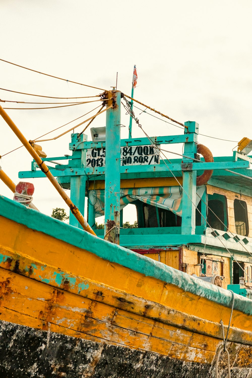 a yellow and blue boat sitting on top of a body of water