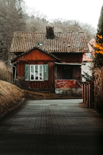 a red house with a tiled walkway leading to it