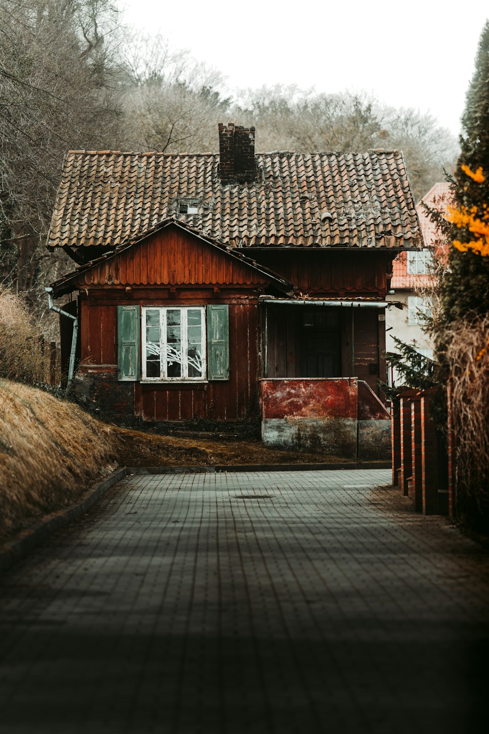 a red house with a tiled walkway leading to it