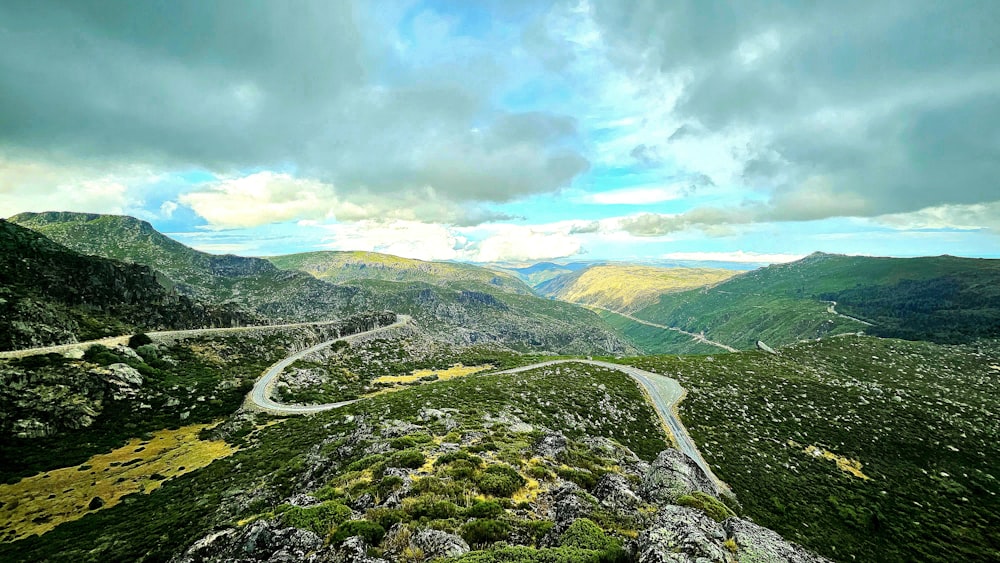 a scenic view of a winding road in the mountains