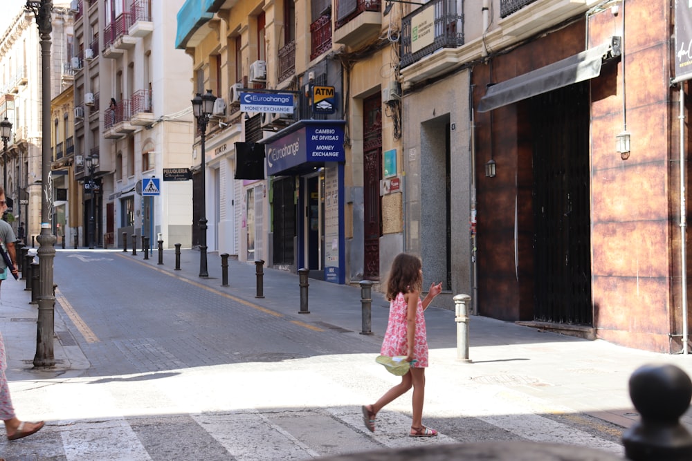 a little girl walking across a cross walk