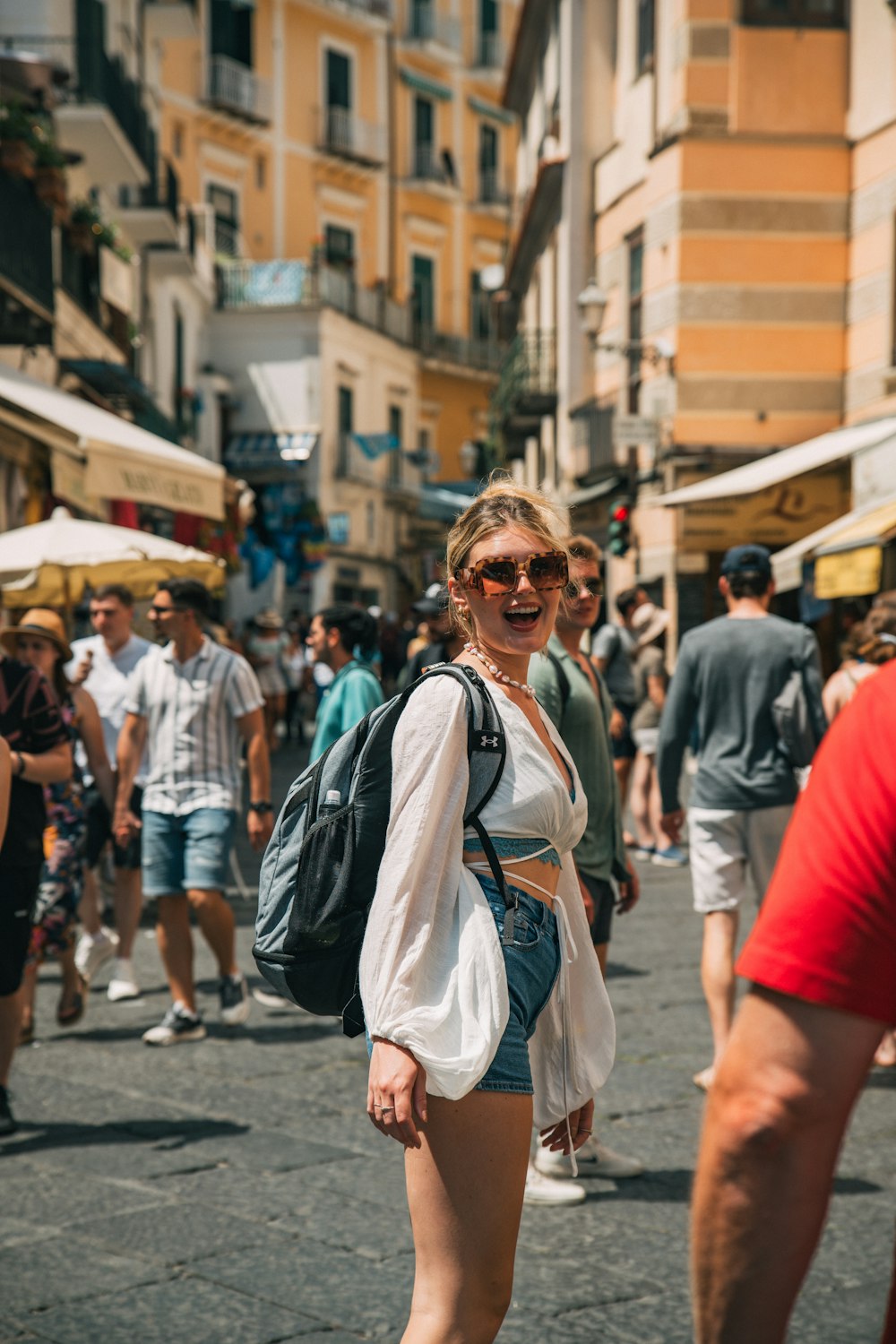 a woman walking down a street next to a crowd of people