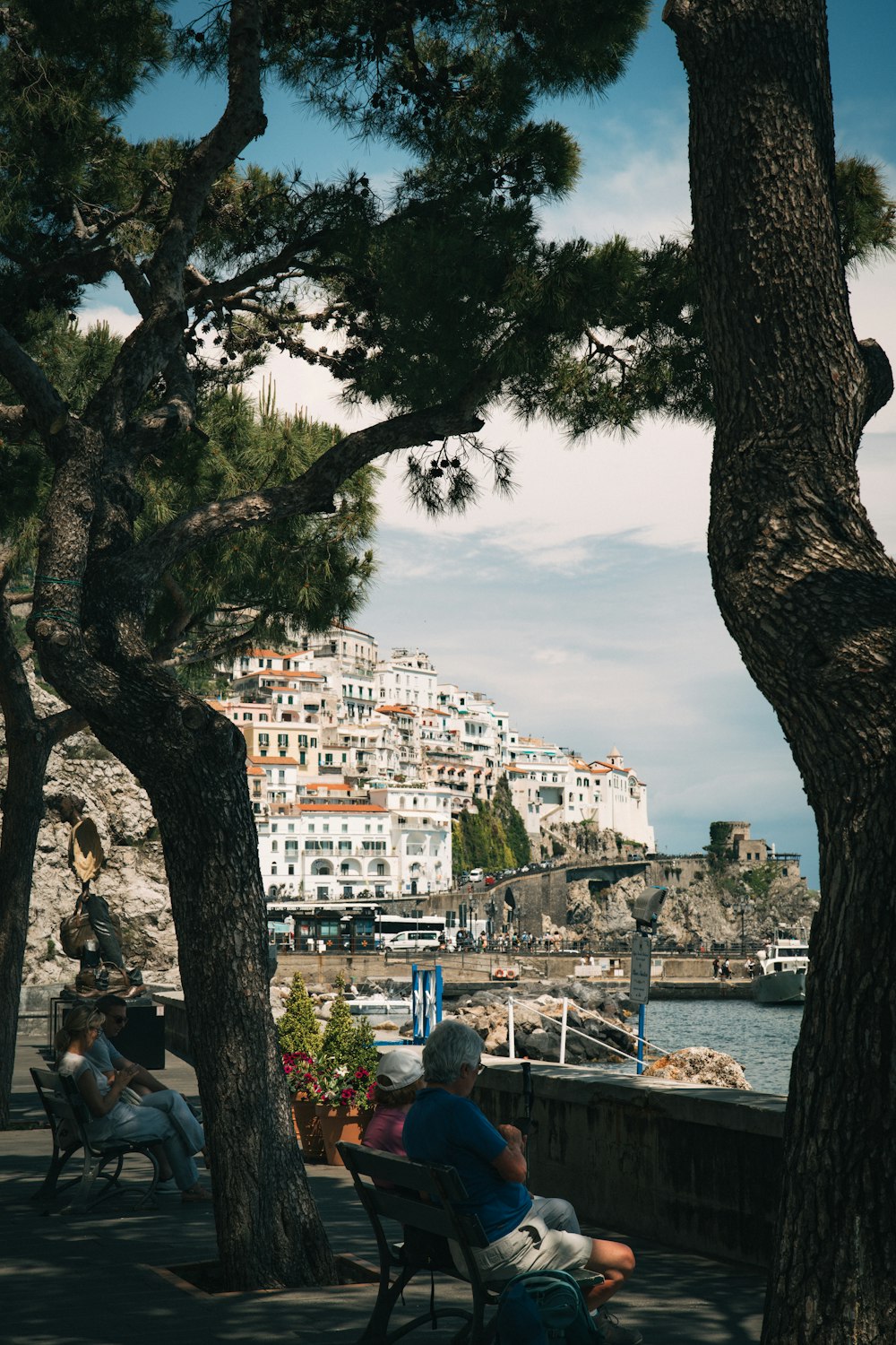 a man sitting on a bench next to a body of water