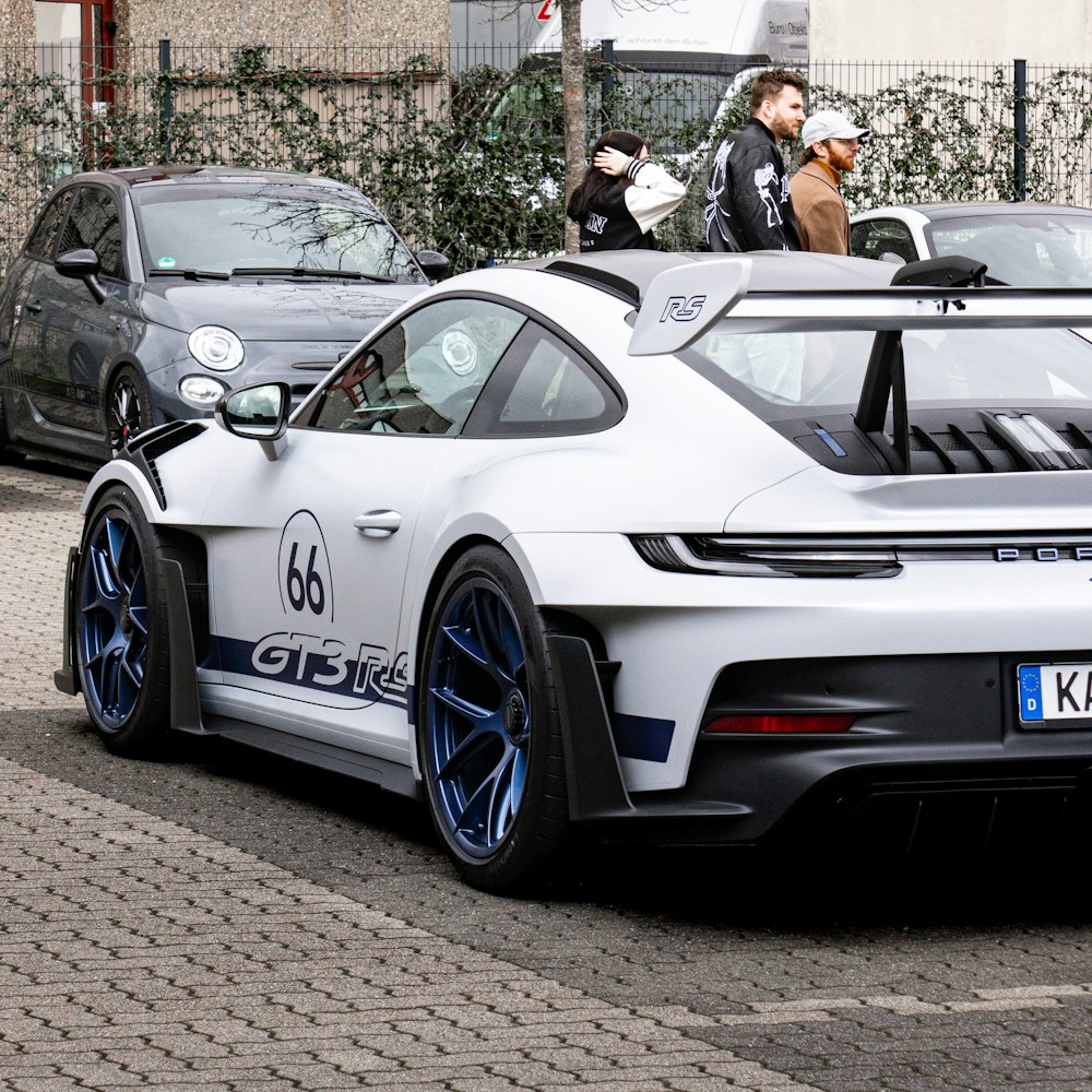 a white sports car parked on the side of the road