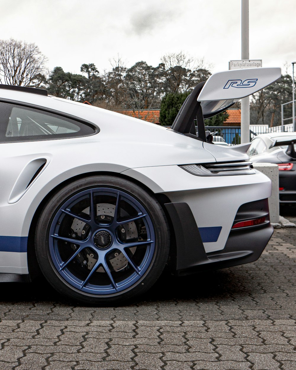 a white sports car parked in a parking lot