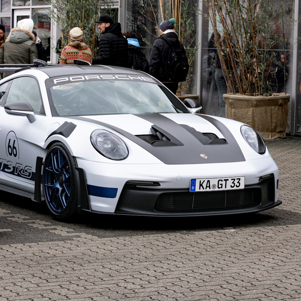 a white sports car parked on a brick road