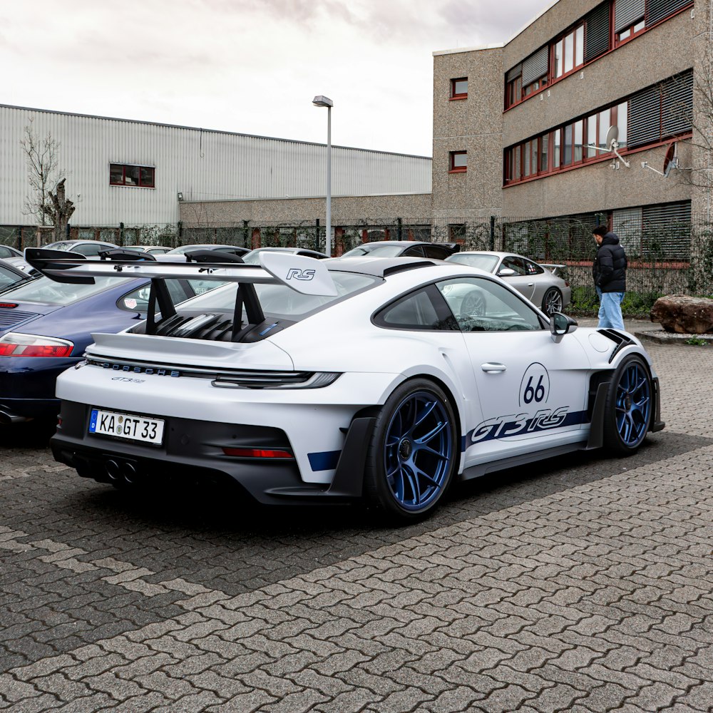 a white sports car parked in a parking lot