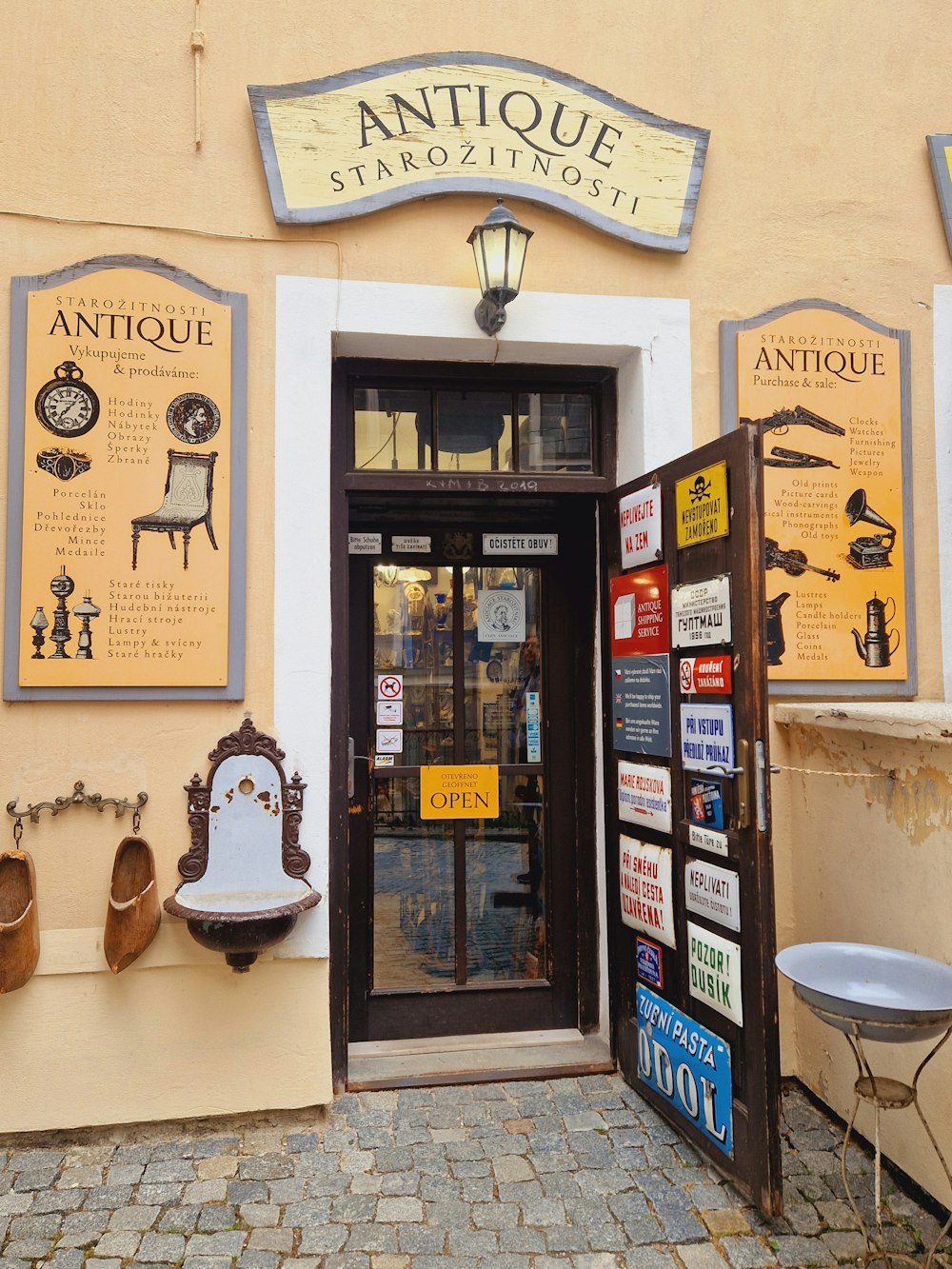 the entrance to an antique store with signs on the wall