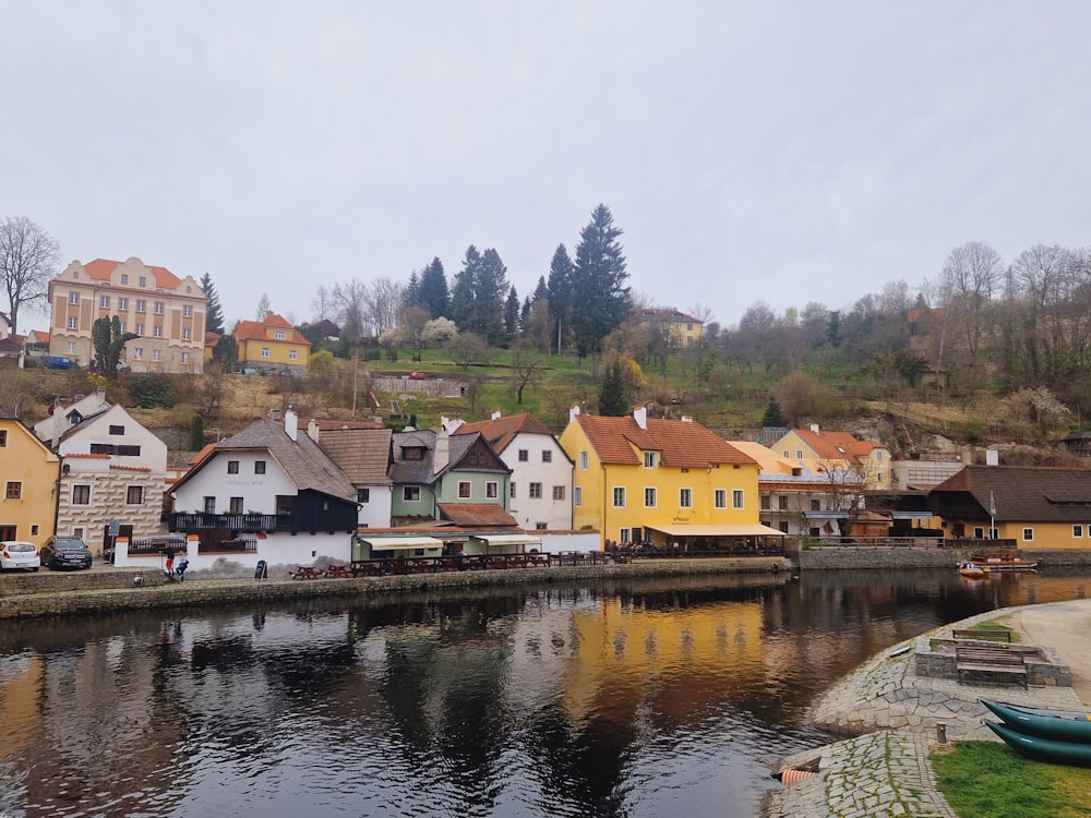 a river running through a small town next to a hillside