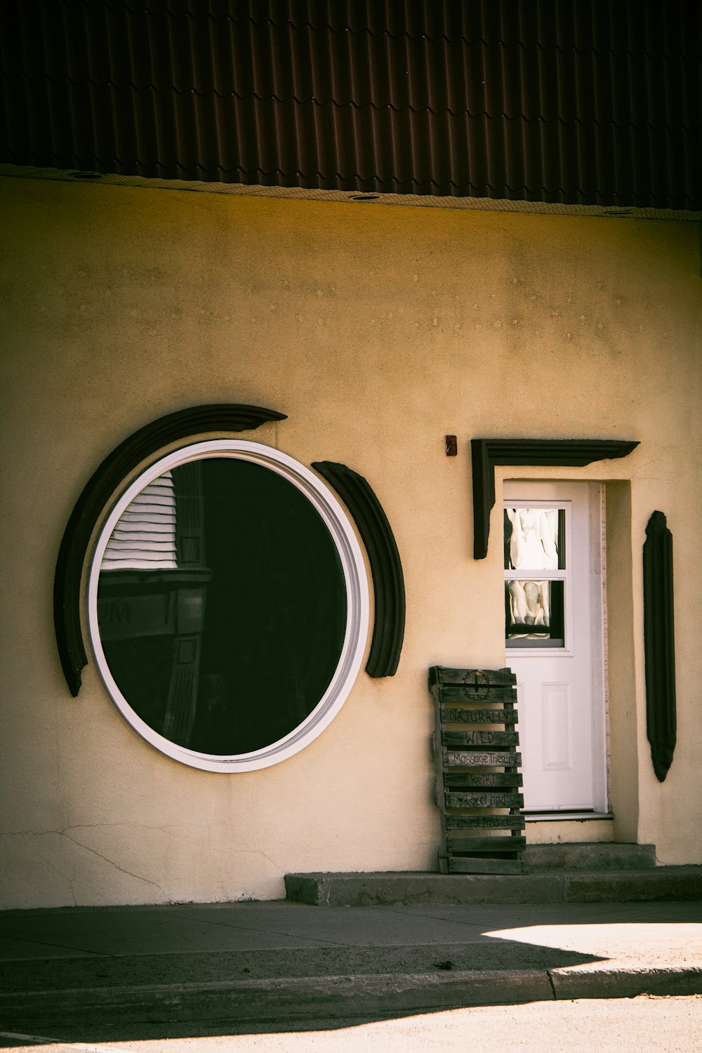 a building with a round window next to a wooden bench