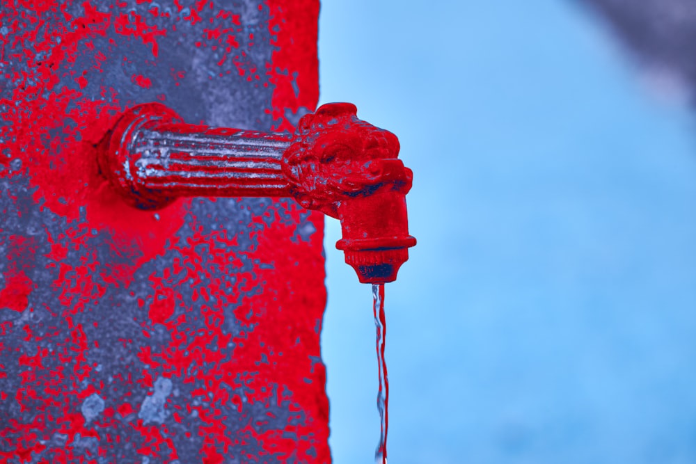 a red fire hydrant with water coming out of it