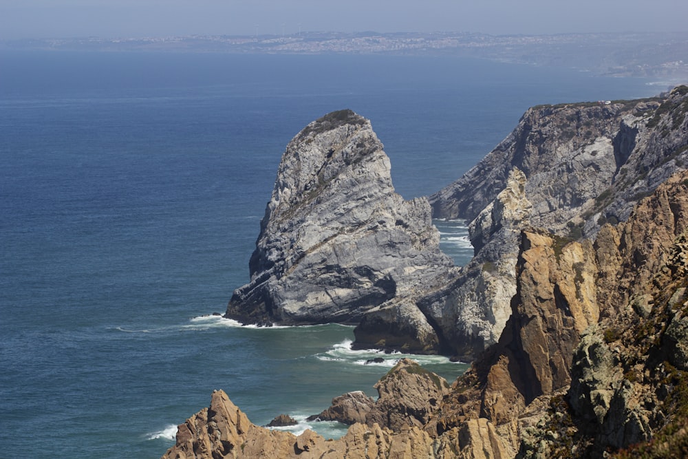 a couple of large rocks sitting on top of a cliff