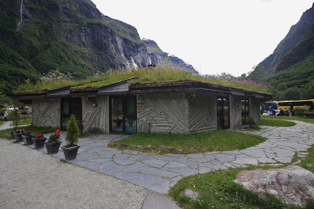 a small building with a green roof in the mountains